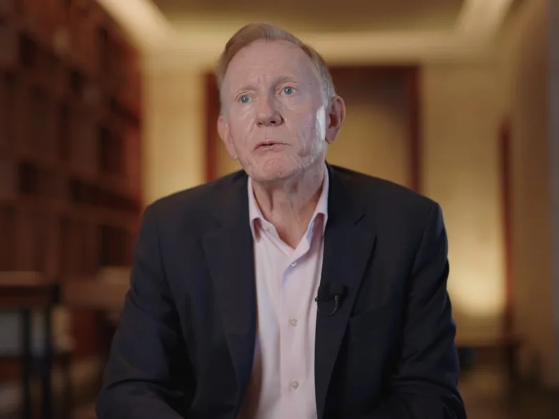 Corporate interview of an executive with a lapel microphone in a warm library setting