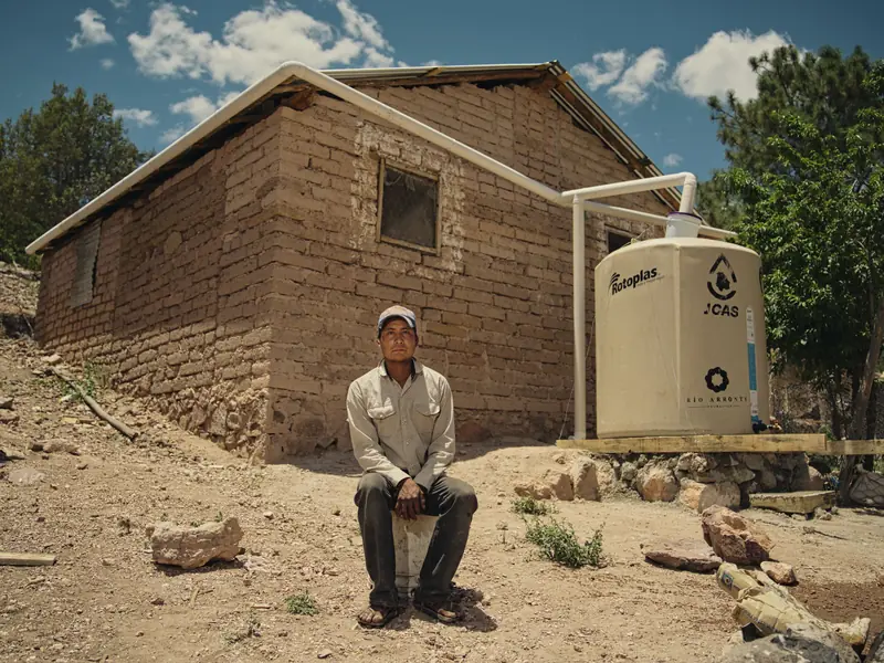 Interview subject outside an adobe house for a news story