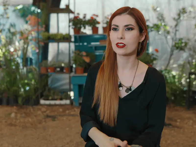 Influencer filmed among plants in a greenhouse