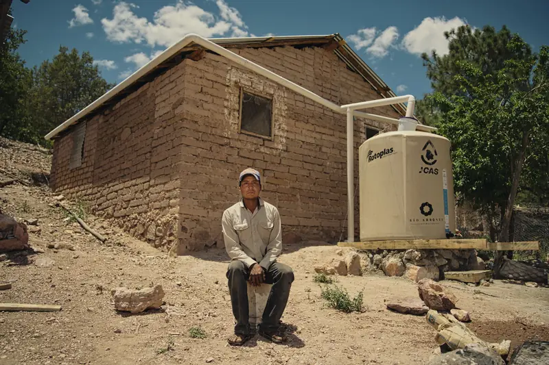 Fixer and news crew in Mexico: interview subject outside an adobe house for a news story